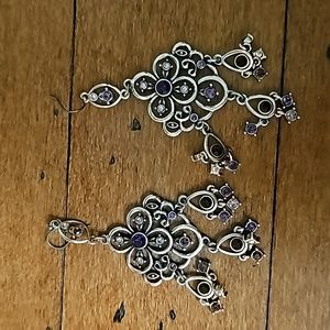 Silver colored earrings with purple stone accents